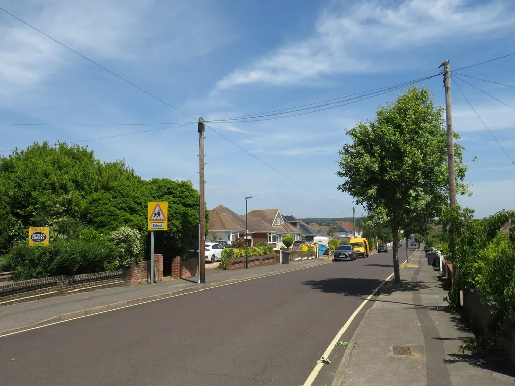 Bungalows on Petersfield Road, Bournemouth, with an estate agent's sale board on the left